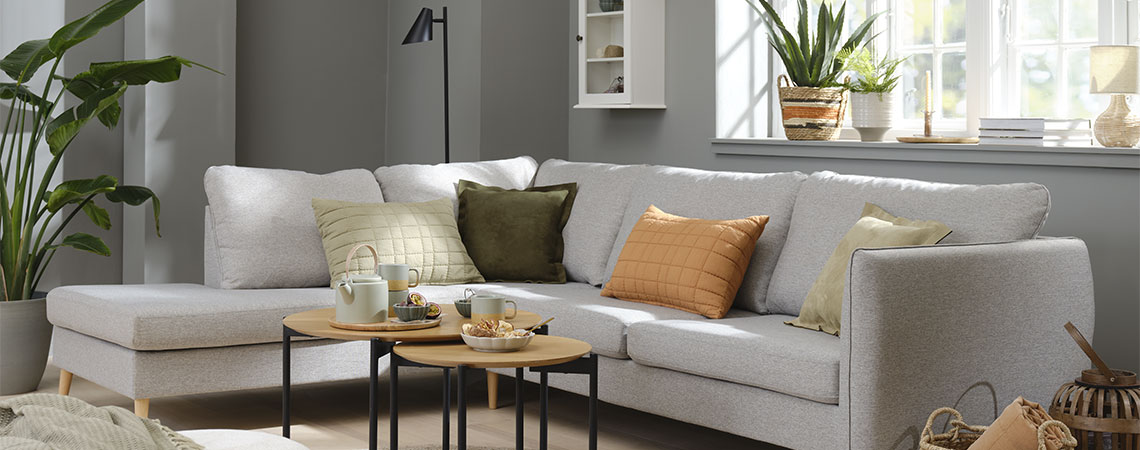 Living room setting with grey sofa and orange, green and beige cushions