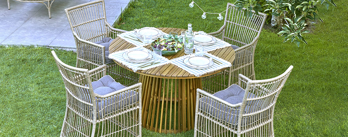 Mesa redonda y cuatro sillas de jardín situadas en el jardín