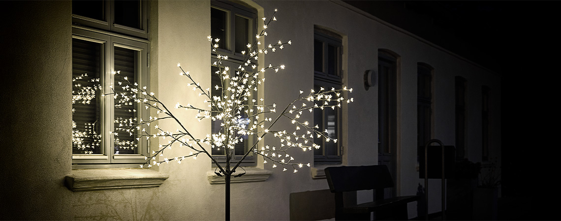 Árbol de luces LED en el exterior de casa en invierno 