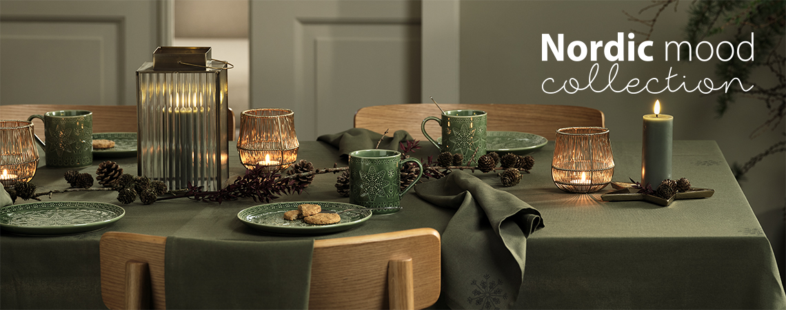 mesa puesta con platos verdes de Navidad, tazas verdes de Navidad, farol y portavelas y velas