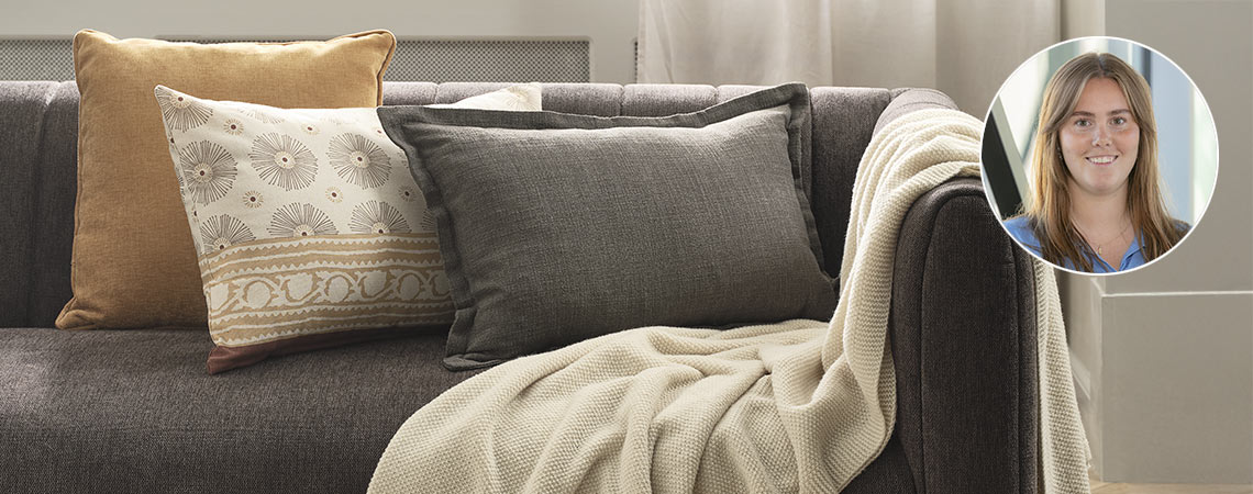 Sofá con tres cojines, una manta y la foto de Josefine Riis Kjeldsen