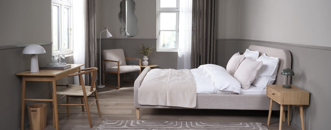 Estructura de cama tapizada en un dormitorio con espacio de oficina