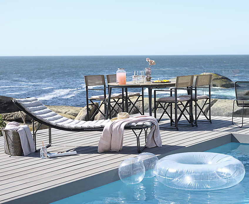 Muebles de jardín al aire libre junto a una piscina, cerca del océano 