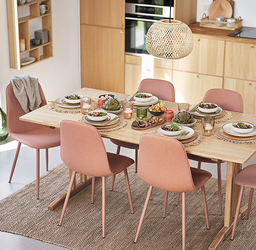 Sillas de comedor en melocotón suave alrededor de la mesa de comedor en la cocina 