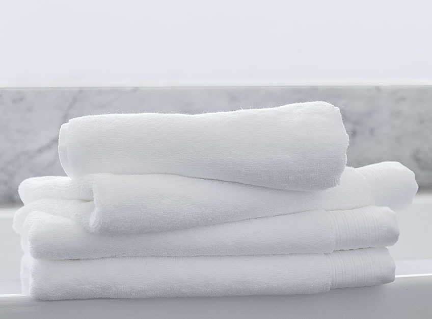 Toallas blancas apiladas en un cuarto de baño