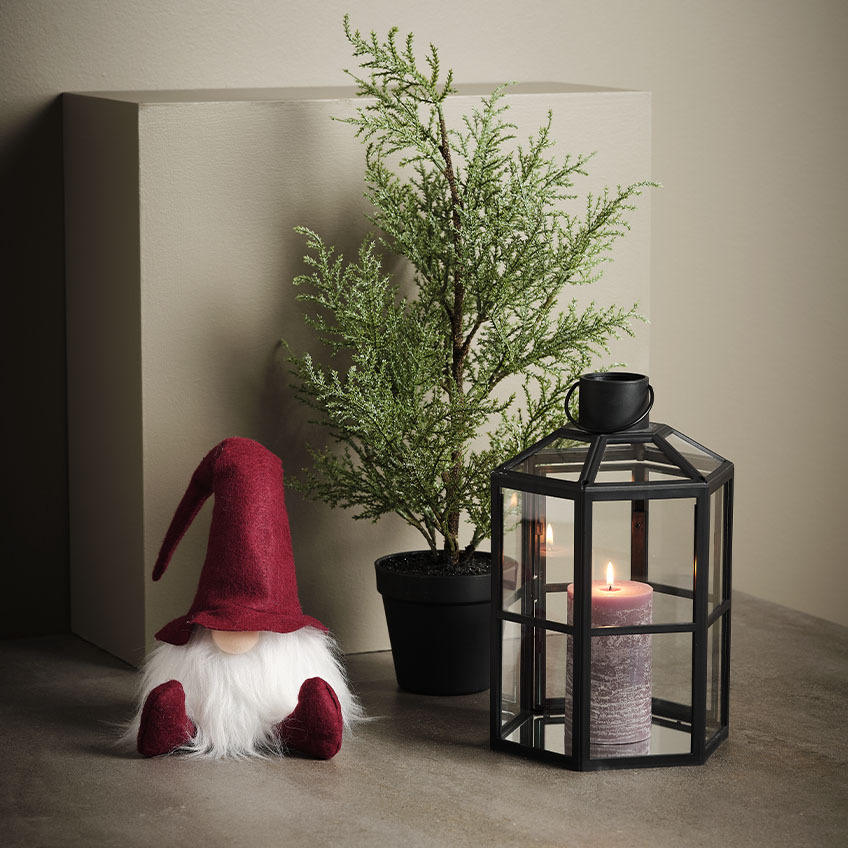 NABBI también es genial para decorar lugares más bajos, como el suelo. Duende navideño escandinavo junto a una planta artificial y un farolillo.