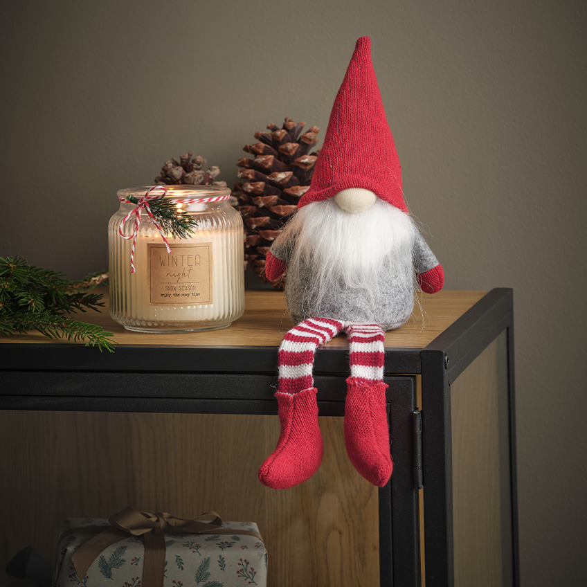 Duende de Navidad con barba blanca, gorro navideño y calcetines.