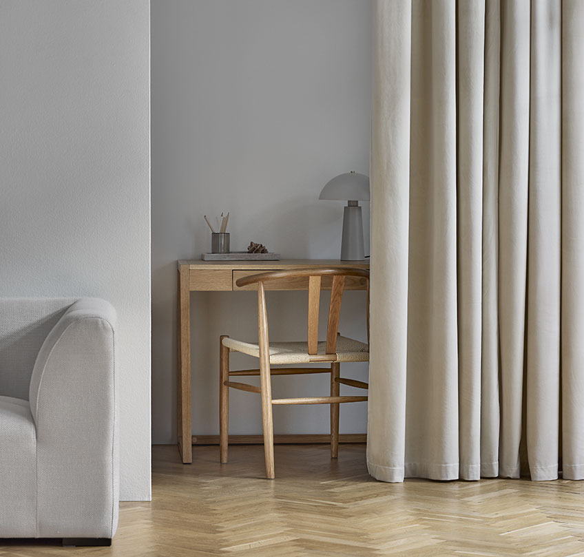 Cortinas beige que separan un despacho con escritorio y silla de un salón