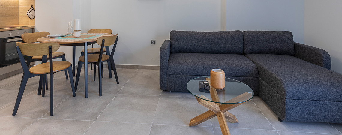 JEGIND dining chair and table and JETSMARK sofa-bed with chaise longue in a cosy open living room Gelasakis - furnished suites