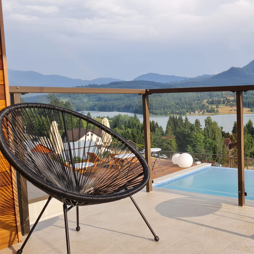 Área de la piscina amueblada con silla y montañas de fondo