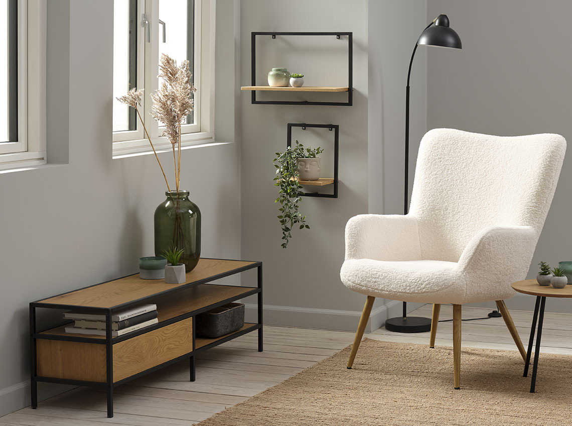 Mueble de TV con espacio de almacenaje, bajo una ventana y al lado de un sillón