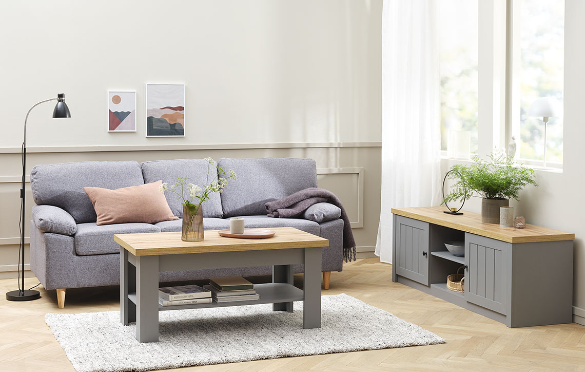 Salón con mueble de TV a ras del suelo, junto a un sofá y una mesa de centro 