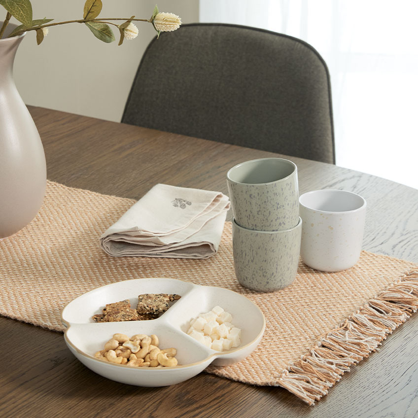 Bol y tazas sobre una mesa de comedor