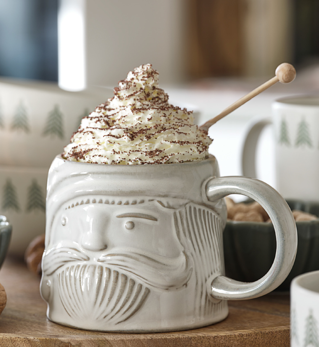 Taza de Navidad con un chocolate caliente con nata por encima y espolvoreado de cacao