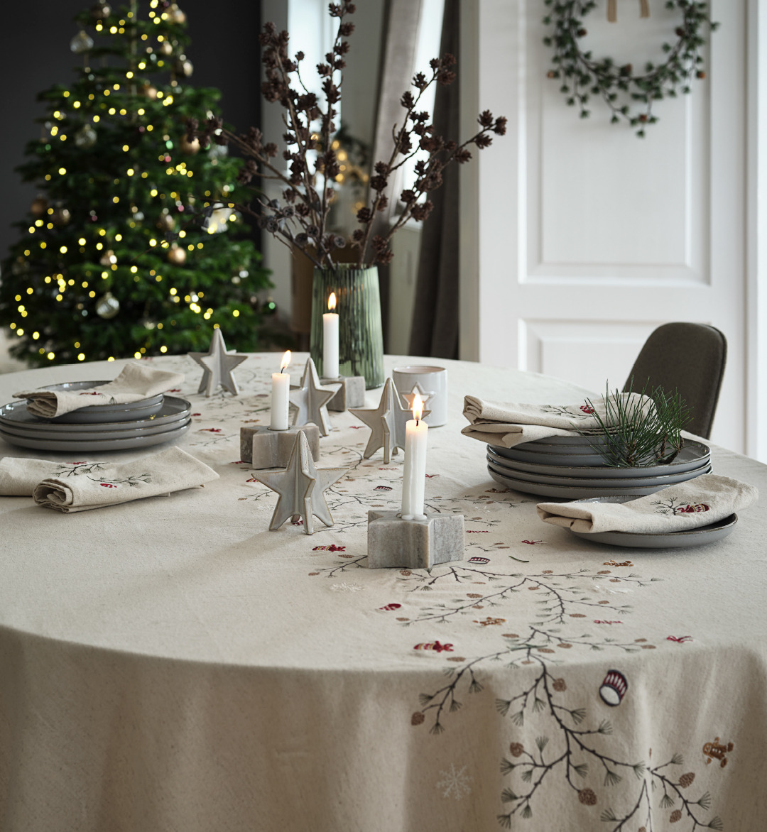 Mesa de Navidad hermosamente decorada con un mantel navideño bordado