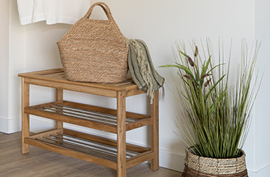 Wardrobe area with shoe storage, plant and bag.