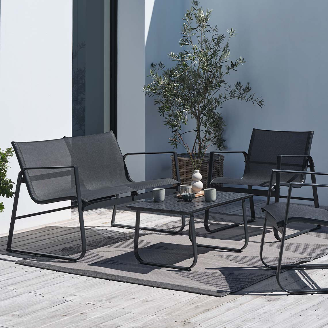 Conjunto de muebles de jardín HORNSLET que no requiere mantenimiento Conjunto de muebles de jardín de color negro que no requiere mantenimiento en una terraza