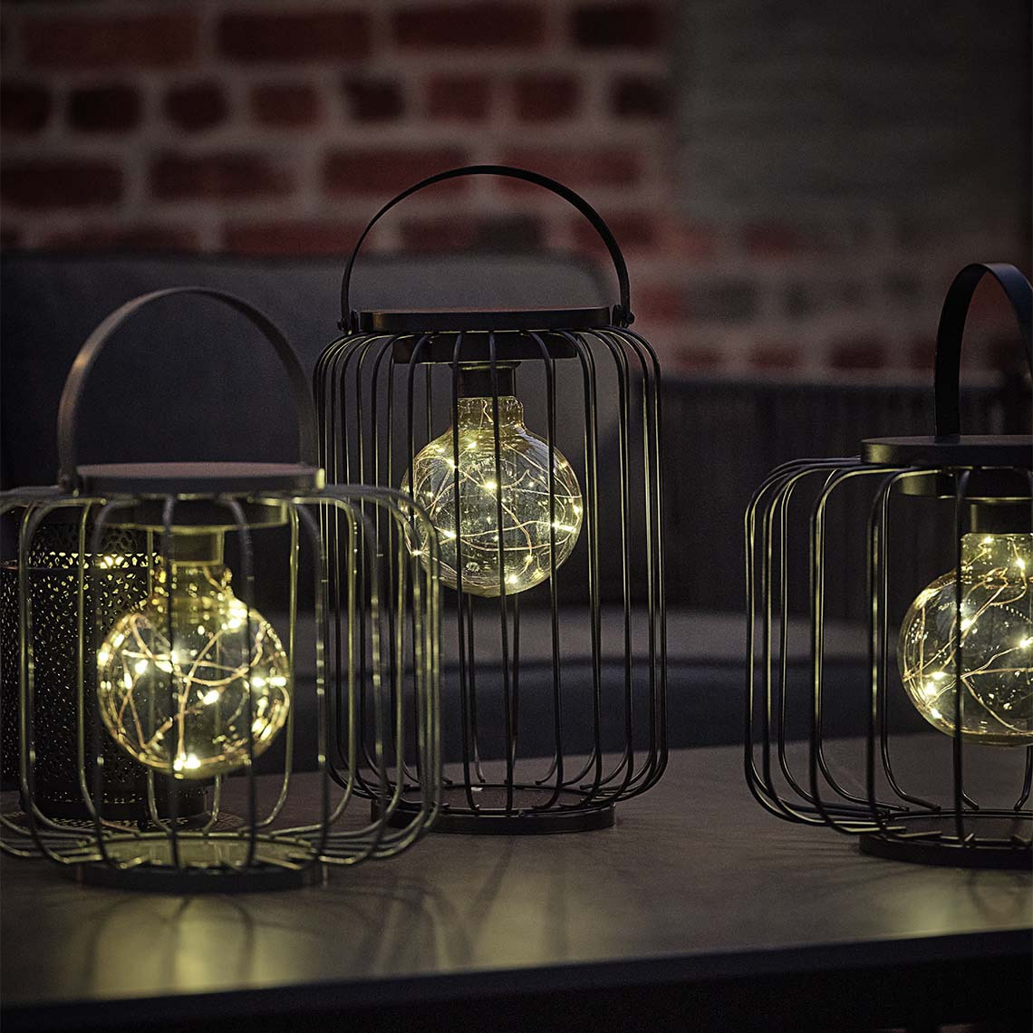 La lámpara a pilas GLENTE está disponible en dos tamaños Lámpara exterior a pilas con marco de alambre de acero abierto y bombilla LED decorativa