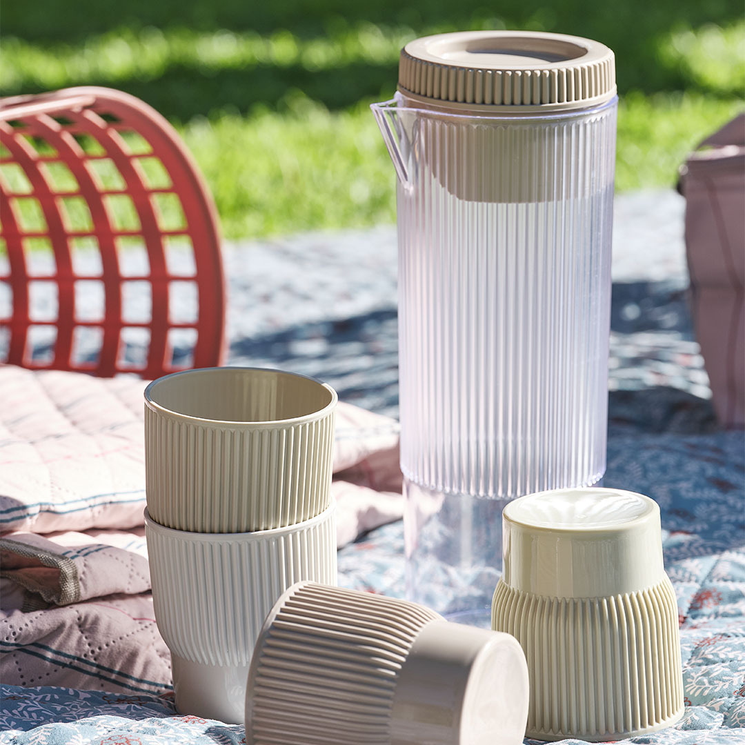 Jarra TJIM para picnic con cuatro tazas a juego Esenciales para picnic, incluyendo una jarra con cuatro tazas a juego sobre una manta de picnic