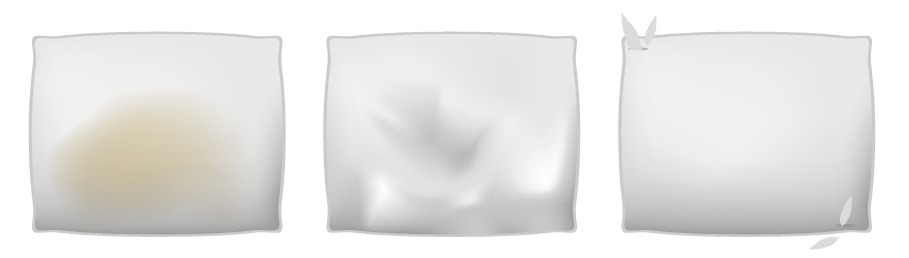 Una almohada manchada y descolorida, una almohada con relleno apelmazado y una almohada con agujeros en su funda de tela Una almohada manchada y descolorida, una almohada con relleno apelmazado y una almohada con agujeros en su funda de tela