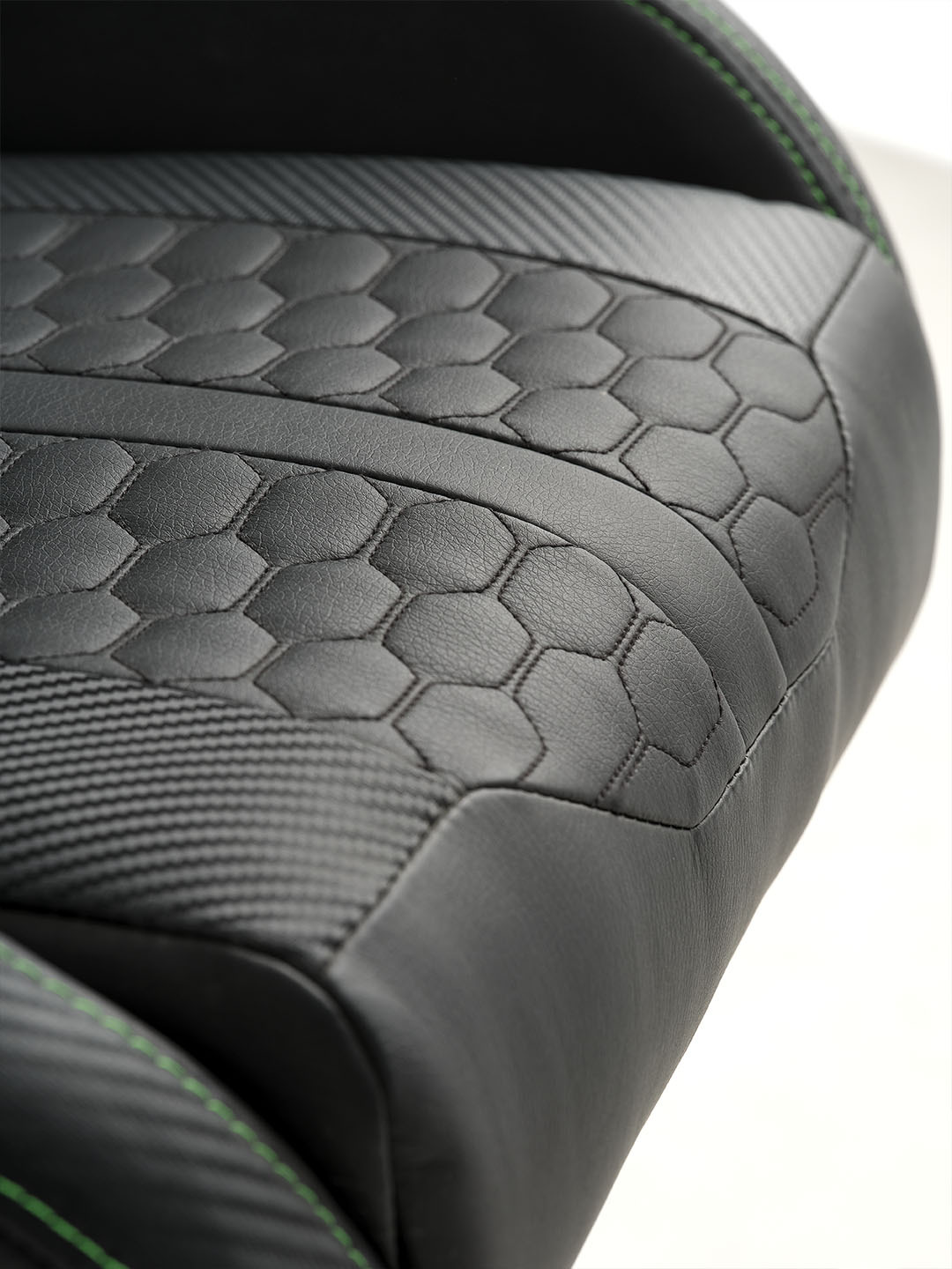 Asiento de silla para juegos Racer de color negro con patrón hexagonal en relieve y detalles en fibra de carbono.