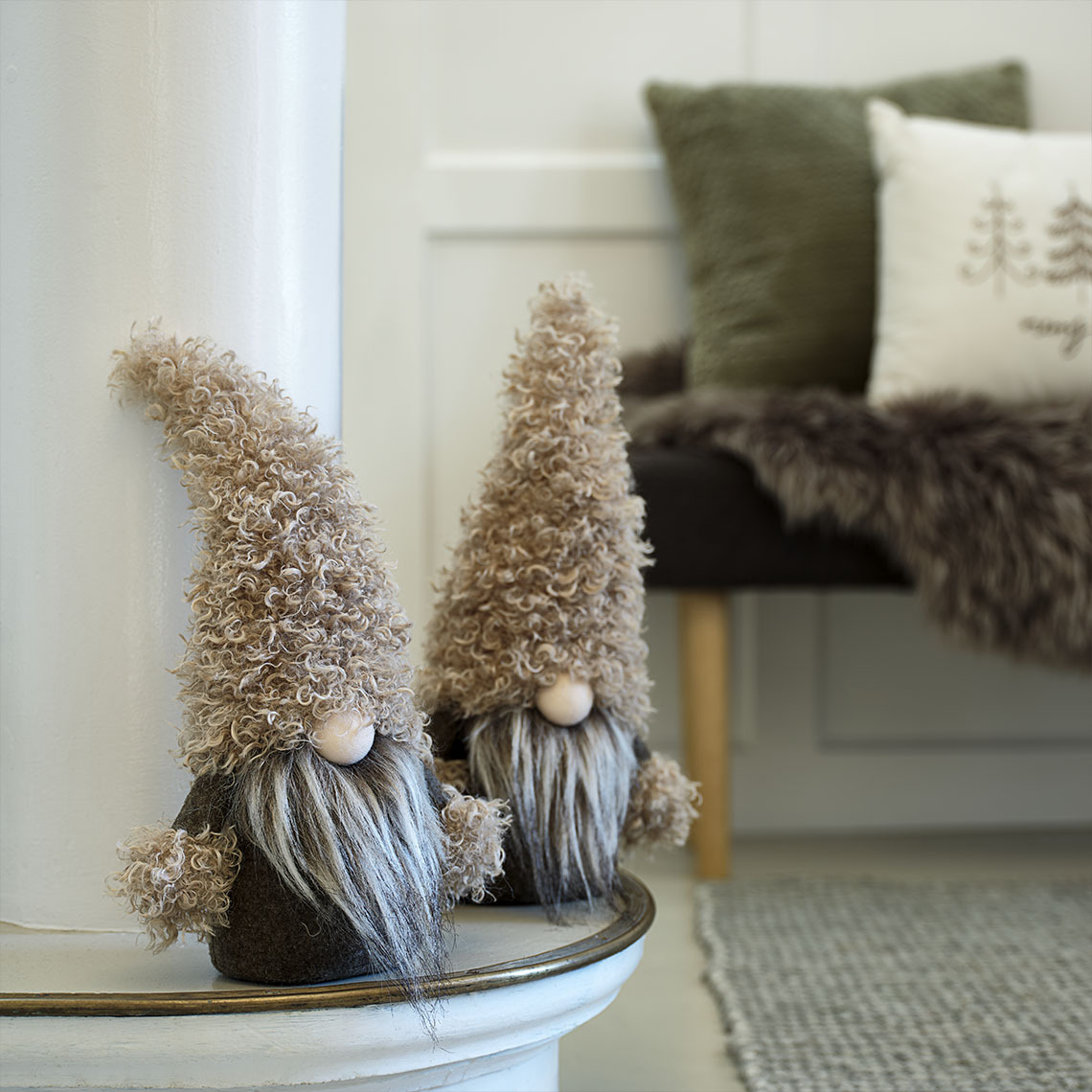 Duende de Navidad LARVIKIT en suaves tonos verdes y marrones Pequeños duendes navideños decorativos en tonos verdes y marrones sobre un aparador