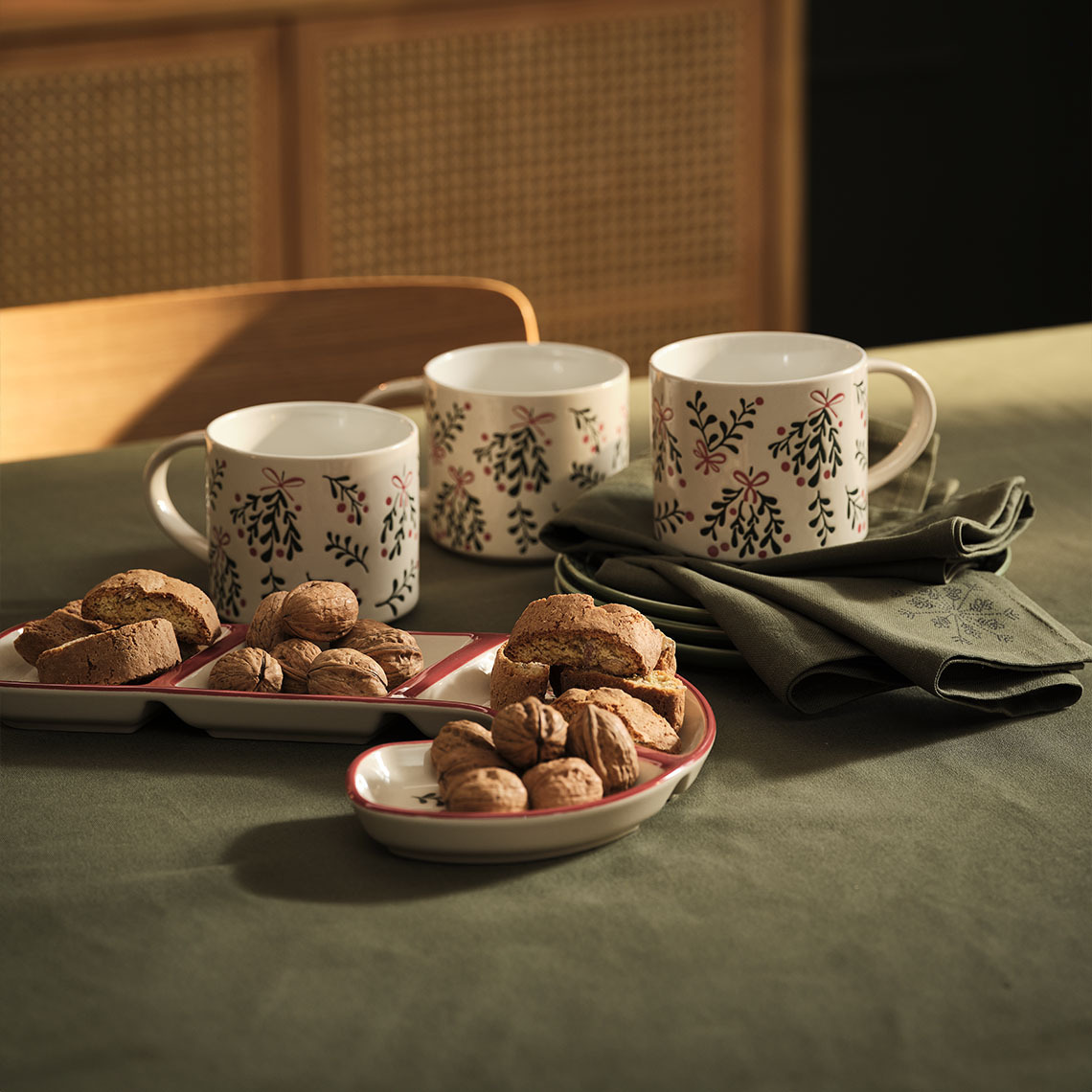 Tazas, bol y servilletas de Navidad en una mesa