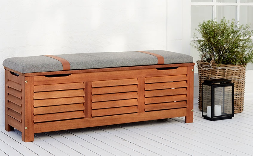 Banco de jardín KARLBY con espacio de almacenamiento y asiento Banco de madera para exteriores en un patio con jardinera y farol