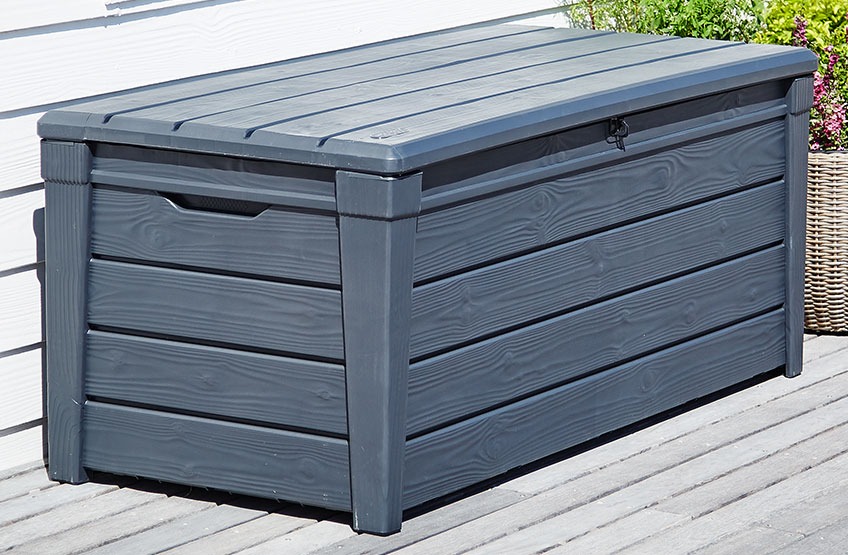 La caja de cojines SVENDBORG también puede utilizarse como banco Baúl de cojines gris en un patio de madera