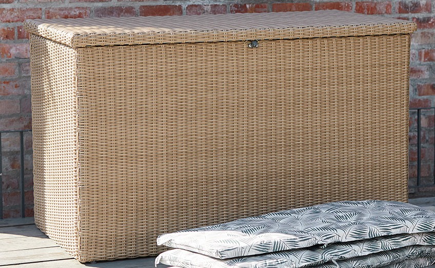 La caja de cojines TAMBOHUSE también está disponible en negro Caja de almacenamiento de jardín grande en un patio de madera