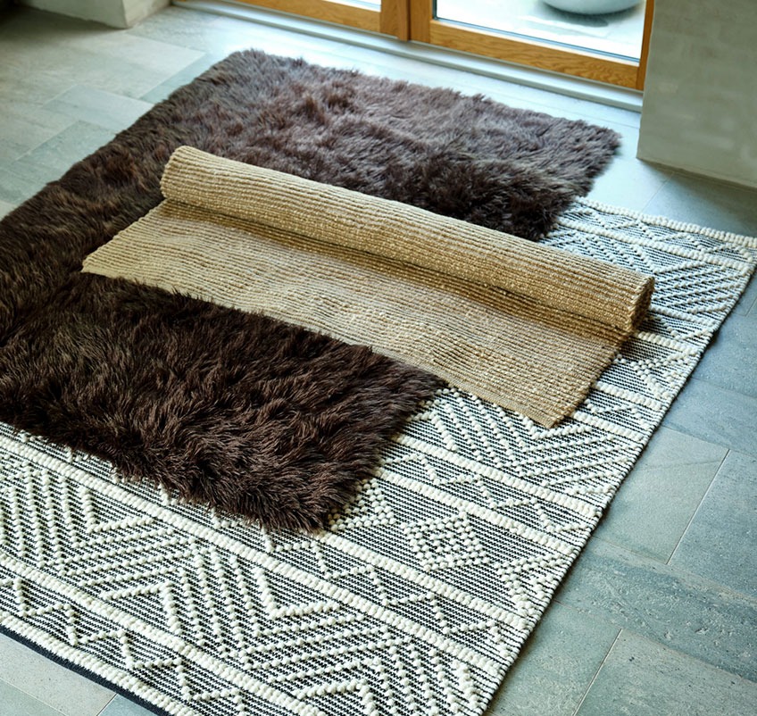 Brown rug, patterned rug and jute rug on the floor 