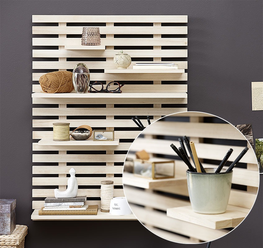 Wall mounted shelf with stationery, notebooks, and candleholders