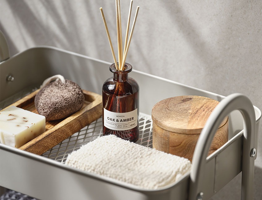 MOHEDA scented oils, VAD bath sponge, and ARDALA storage jar Scented oils, wooden jar and bath sponge place on small console table