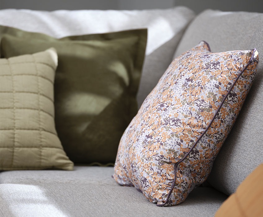 Grey sofa with floral and green cushions