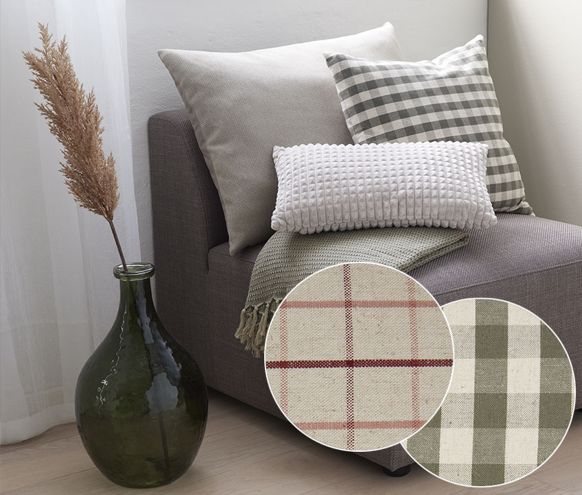 VALERIANA cushion is available in two different checkered designs Grey, off white and checkered cushion in an armchair