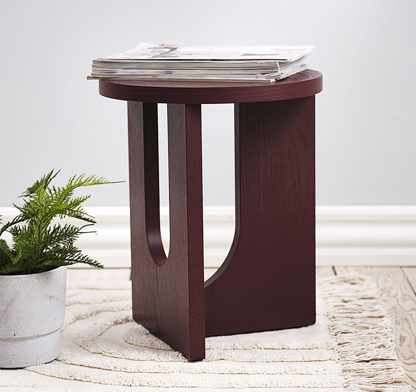 Mesa auxiliar ARCH Mesa auxiliar de color burdeos con tallas escultóricas redondas.