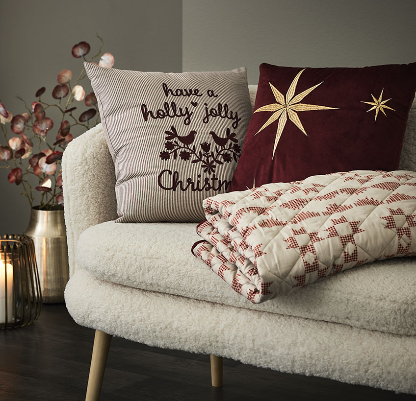 NIDHUG and RIND cushions and TRILOBIT quilted blanket in GISTRUP sofa Cushions and quilted blanket with Christmas motifs in a white sofa