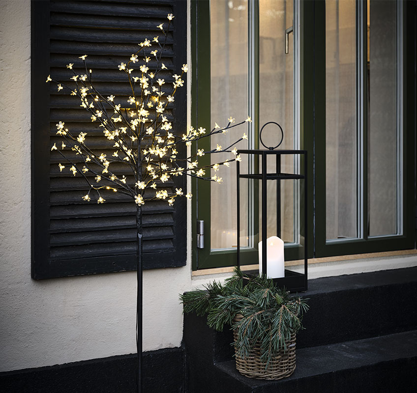 Light tree with small flower lights and lantern with white candle