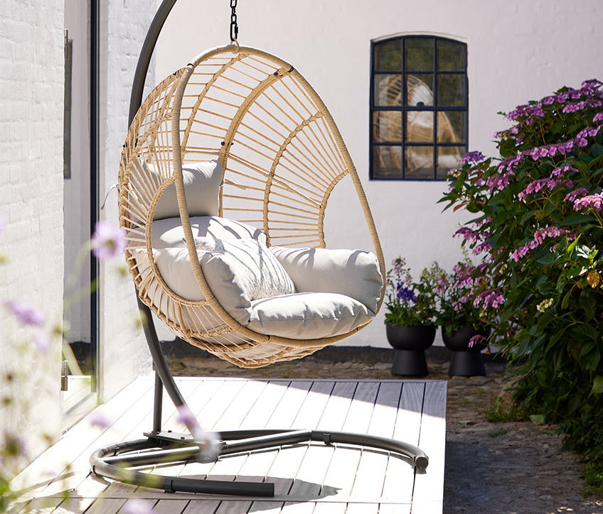 Silla colgante GJERN Silla colgante en color natural en una terraza